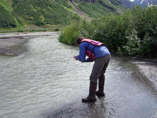 Heidi getting water sample at the inlet from Cascade Glacier