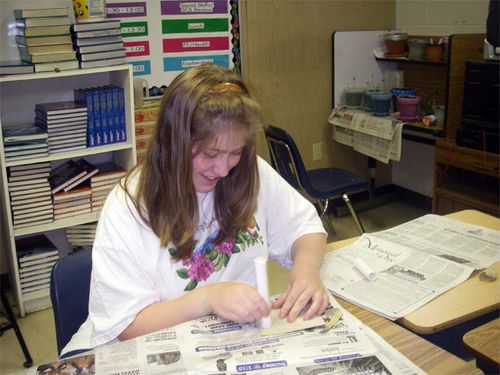 Sharon is sanding a piece of  1/2 inch PVC pipe.