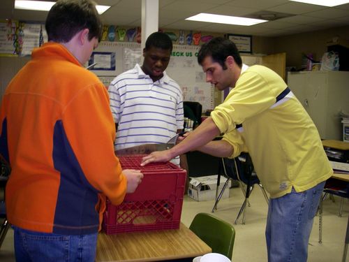 Mr. Tice is helping Michael and DeQuires cut a base.