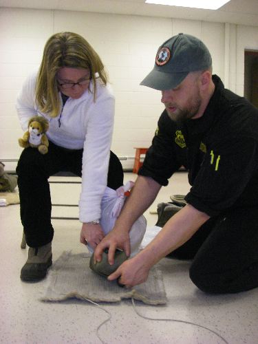 Tuck constructs a boot on Mrs. Ward's foot.