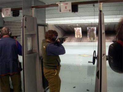 Cathy Geiger firing a shotgun during bear training.