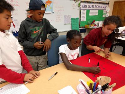 Fifth graders write on Polar Banner.