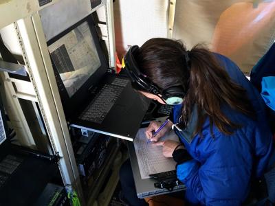 PolarTREC Teacher Kelly McCarthy monitors the Digital Mapping System instrument during a science flight.