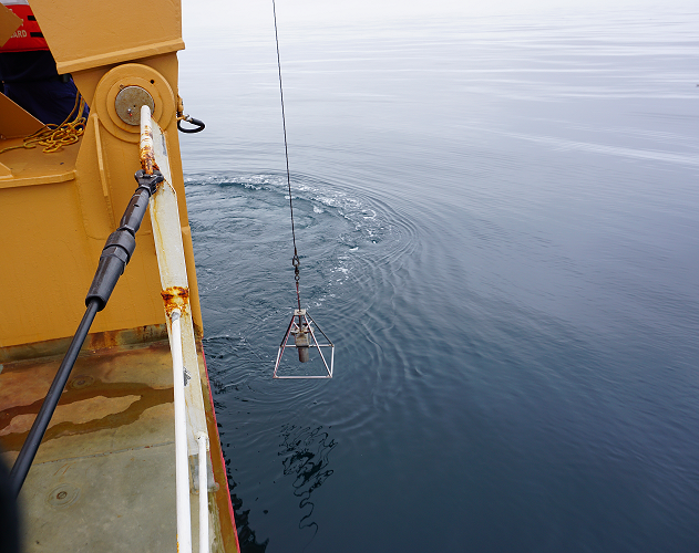 The HAPs core is lowered off the back deck of the USCGC Healy on a calm day in the Chukchi Sea.