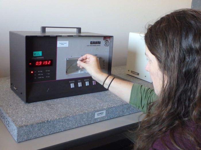 A scientist uses an electrobalance