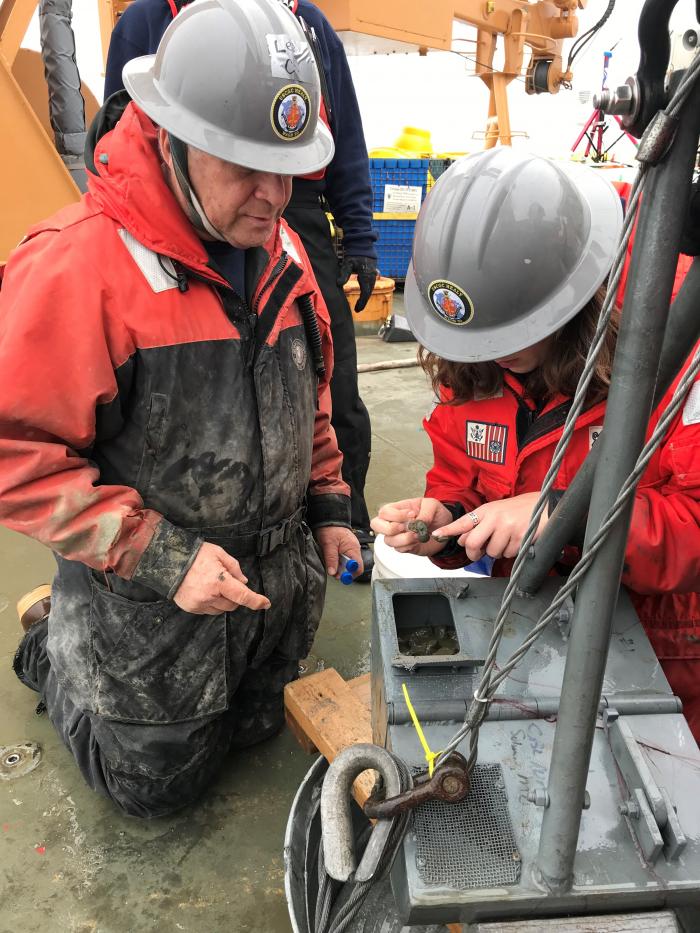 Dr. Lee Cooper and Kelly Kapsar collect surface mud from a trap door on the top of the van Veen grab.