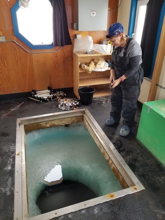 Denise Hardoy Icefishing in a Dive hole on the Jetty