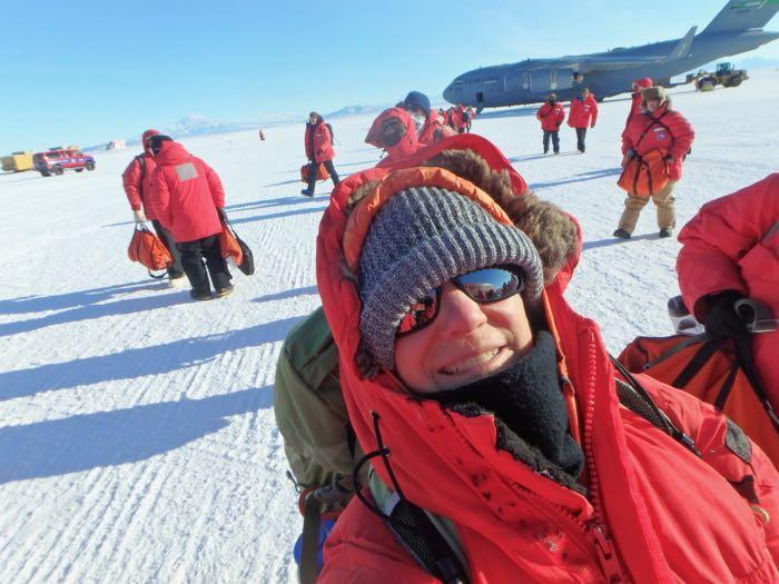 Amy Osborne on the ice in Antarctica with a C-17 in the background