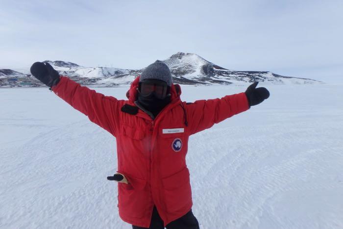 Amy Osborne in a winter coat, hat, goggles, and neck gaiter on the sea ice in Antarctica.