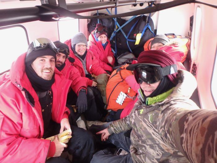 Six people sitting in the back of a Hagglund.