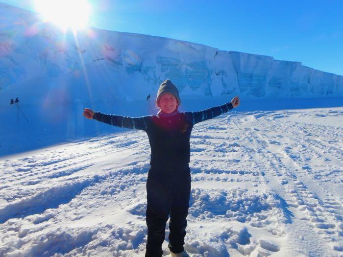 Amy Osborne standing on the sea ice with arms widespread 