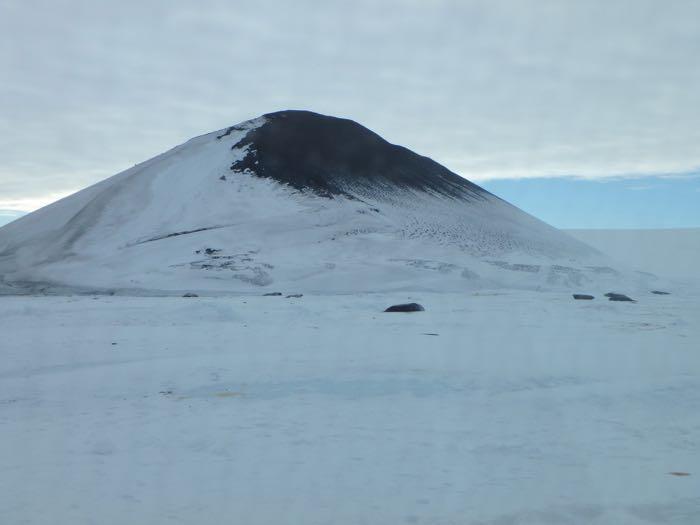 Turtle Rock with snow and Weddell seals in front of it.