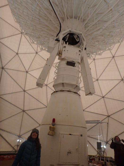 Amy Osborne standing in front of a satellite dish