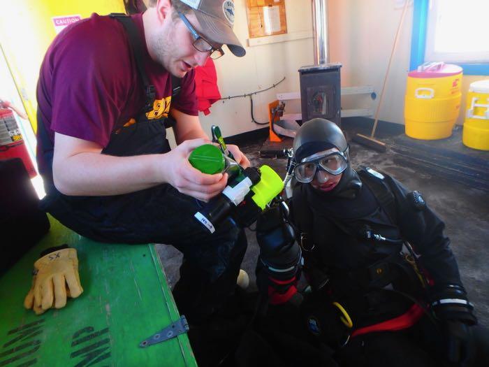 Graham helps Aaron with his flashlight and collecting container.