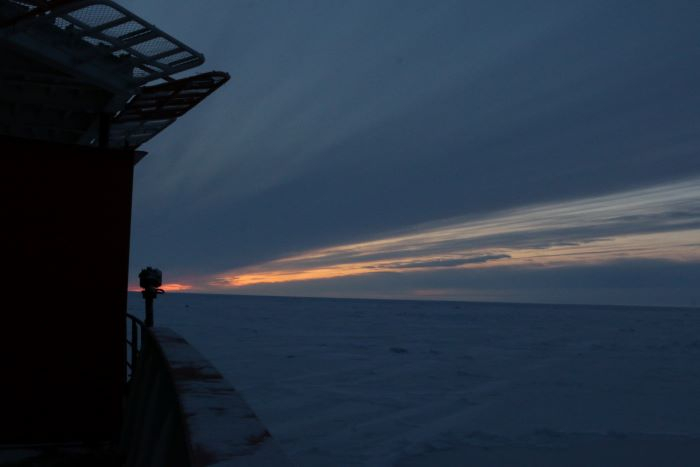 A ship moves through a patchwork of Arctic sea ice