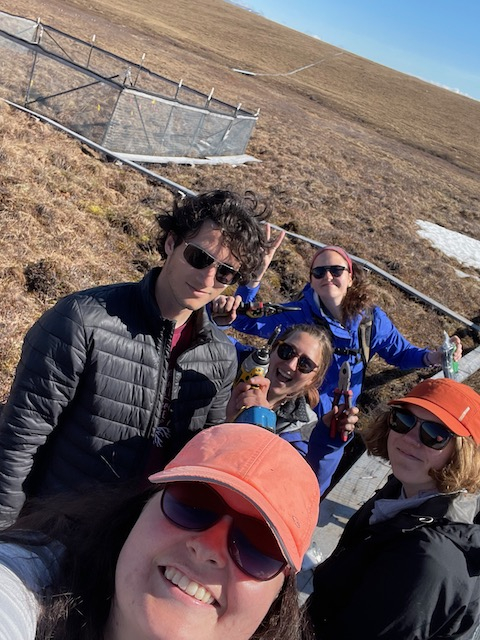 Team vole stands in front of a fenced in enclosure. 