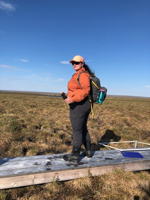 Liza stands on a boardwalk with Bear spray in hand!