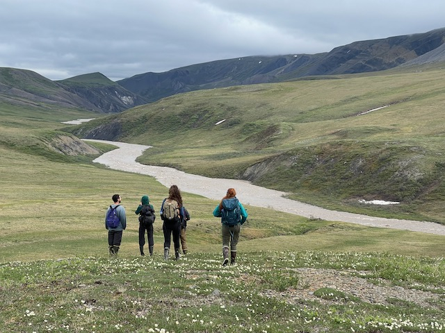 The group stands in a green landscape in front of the river. 