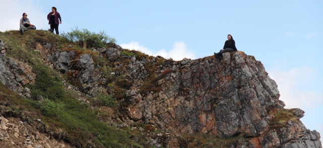 Liza sits out on a rock ledge while Jenn and Sarah chat on the slope. 