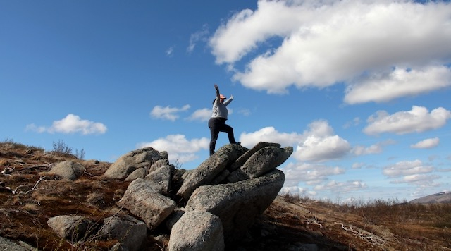 Liza stands on a bunch of rocks.