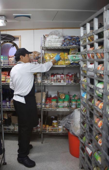 Chef Ariel Toledo checks the stock in the galley storeroom