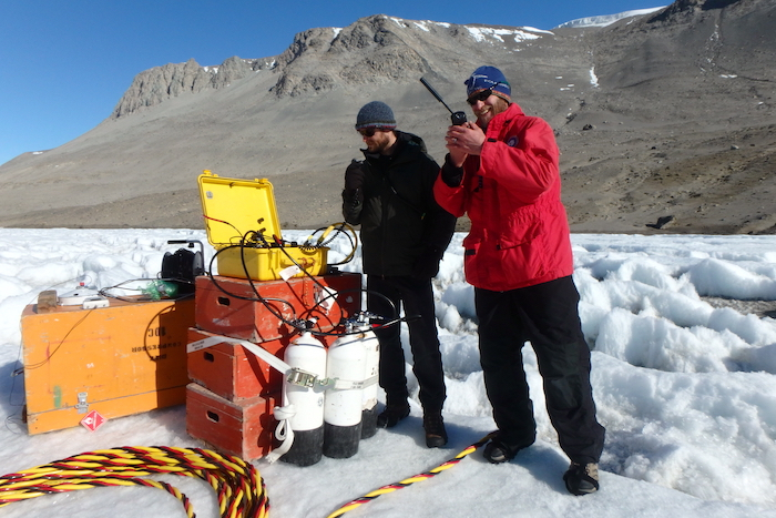 Kevin Dickerson Skypes with Dr. Shawn Devlin, who is diving under 12 feet of ice collecting samples.