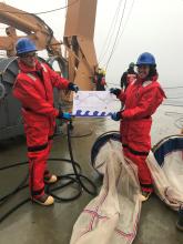 Janey Duffy-Anderson and Chrissy Hayes hold a flag made by a student in Nome's Ecology Explorers program.