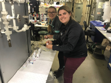 Piper Bartlett-Browne and Caitlin Meadows take paper towels out of the crushed cups in the lab.