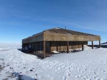 Scott's Discovery Hut. A wooden structure on the icy land near the sea ice in Antarctica.