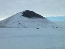 Turtle Rock with snow and Weddell seals in front of it.