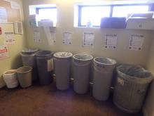 Cans at the end of a hallway labeled recycling, landfill, and food waste.