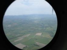 Trees and grass seen through an airplane window.