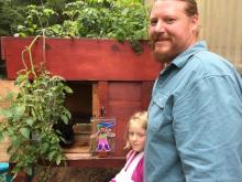 Father, daughter, and a drawing in front of a rabbit hutch