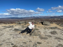 Image shows Liza posing on a rock. 