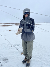 Steve standing in a snowy landscape behind frost covered cables. 