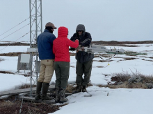 Steve, Sarah, and Jeremy hang the MISP on the cables in a snowy landscape.