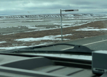 A river criss-crosses in front of the truck. Some bluffs are seen in the background. 