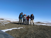 Steve, Liza, Sarah, and Jeremy stand linked arm in arm with their backpacks on before heading up to Imnavait.