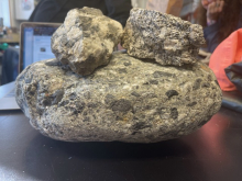 Three rocks sitting on a table. 