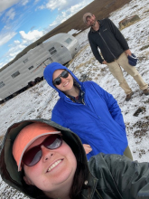 Liza, Sarah, and Jeremy stand in a field of hail. 