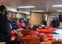 Passengers onboard the Nathaniel B. Palmer gather in the conference room during a safety drill