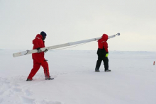 Paul Aguilar and Mark Stephens carrying ice mass balance buoy