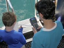 Aely and Wesley recording water column data at the side gate of NG Explorer