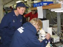 Donna prepares the microscope for Captain Havlik