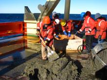 a geologic dredge being worked on , on the back deck