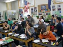 The whole combined classes of 6-8 and 11-12 listen intently.