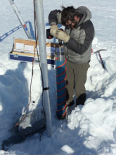 Nikko using ice core drill to make a hole for the new AWS base.