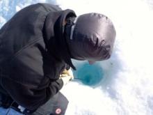 Tyler lowering a camera into the lake