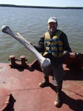 Mark does weight lifting on the barge – a mammoth femur and a dumbbell!