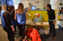 Museum volunteers try on blubber gloves.